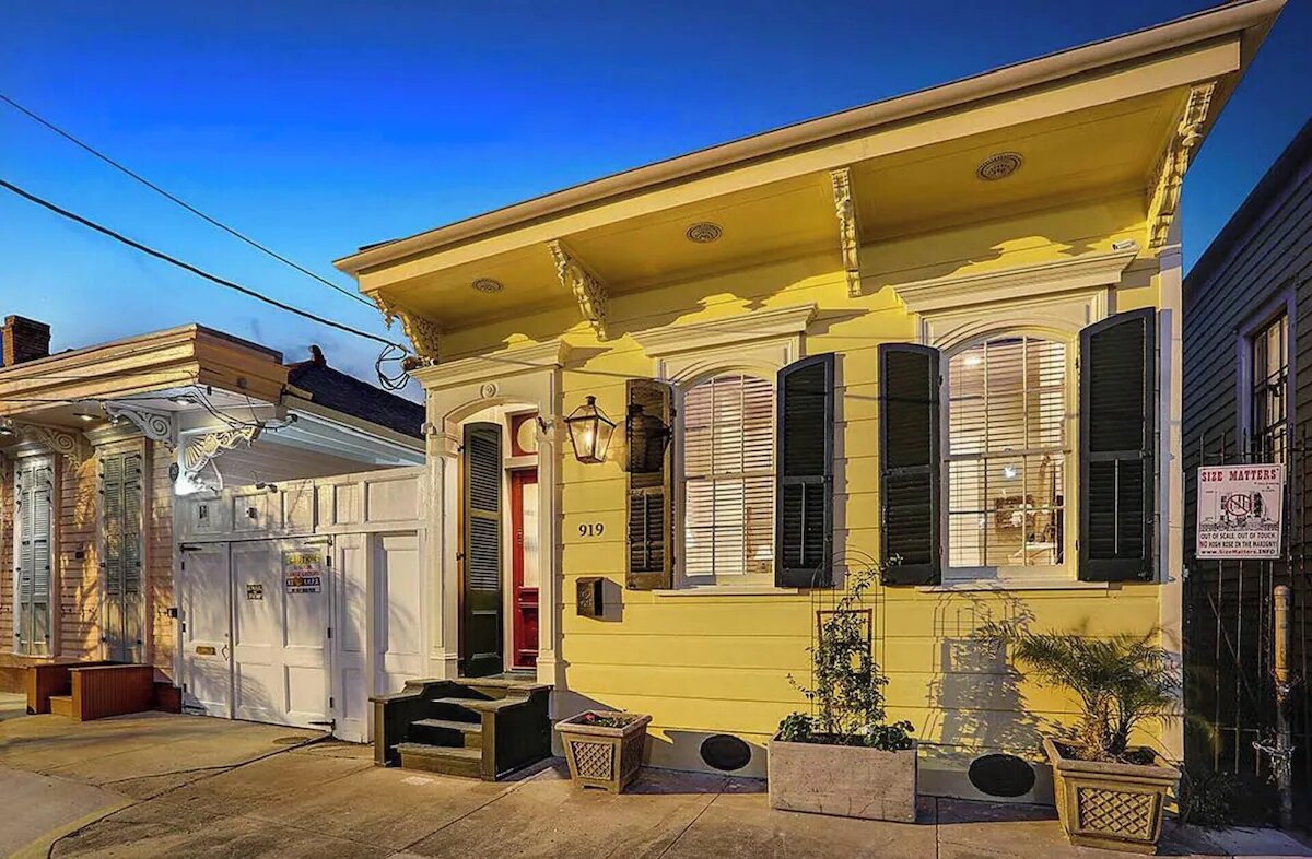 Historic yellow shotgun house in the New Orleans Marigny neighborhood at twilight