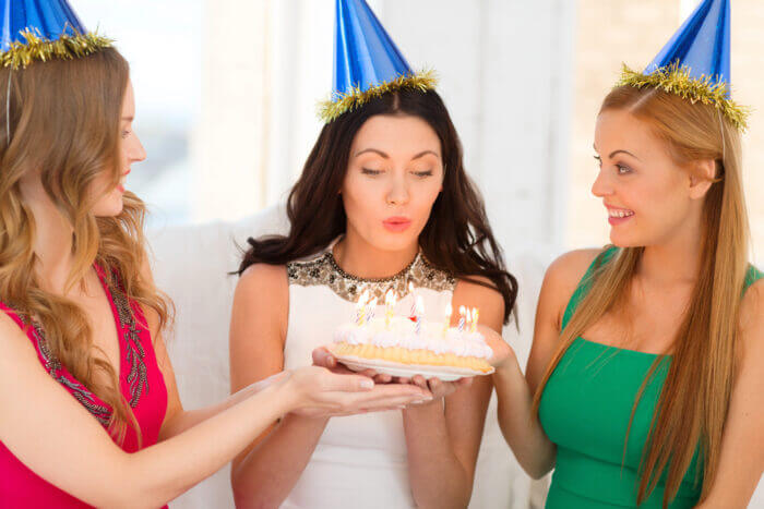 bachelorette party blowing out candles on cake
